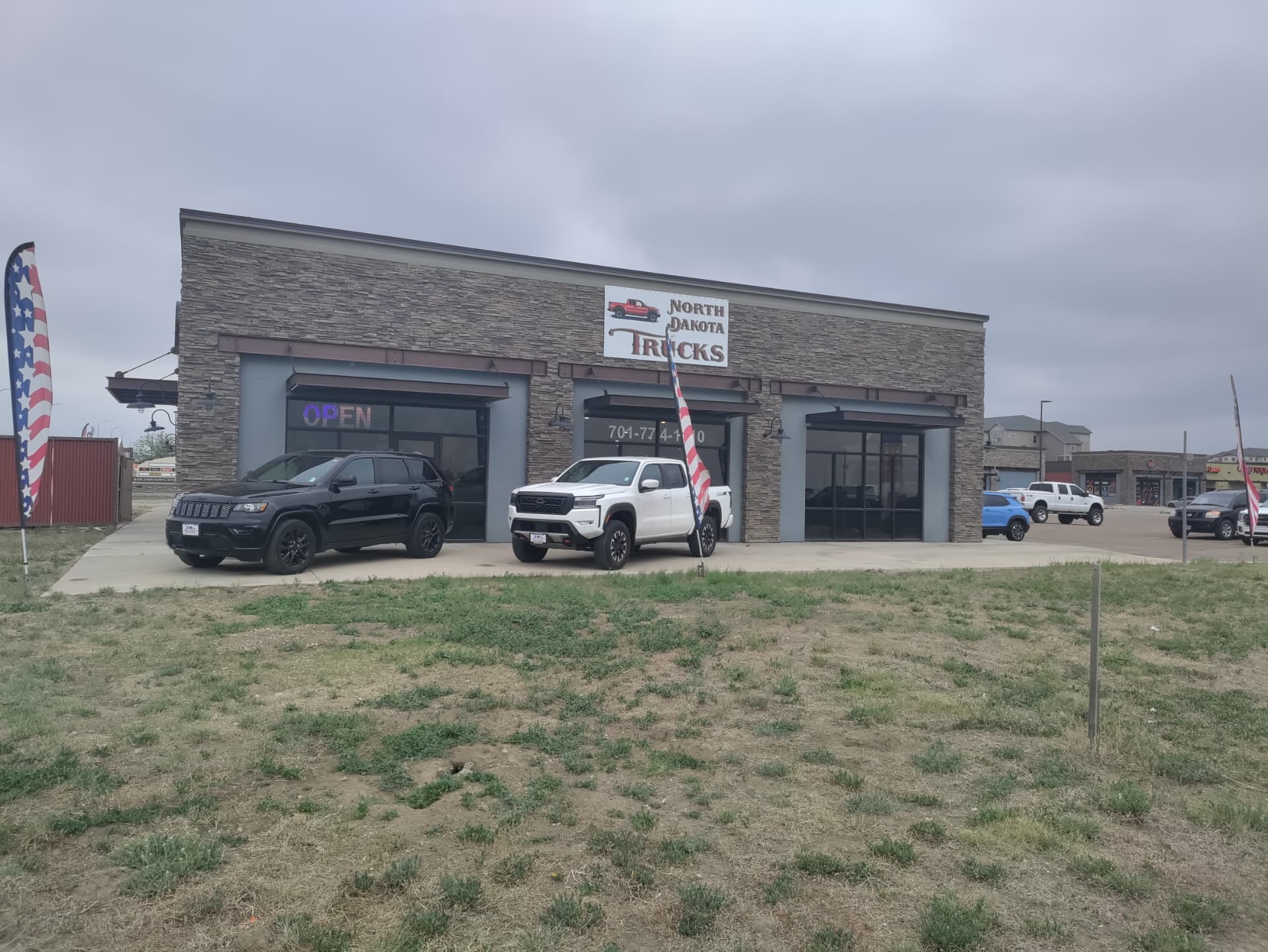 The North Dakota Trucks lot at 910 42nd Street West in Williston, North Dakota, with pre-owned pickups and SUVs out front
